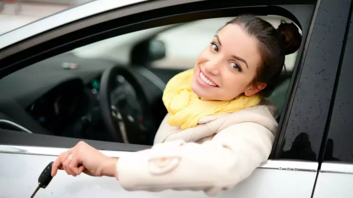 uśmiechnięta kobieta za kierownicą