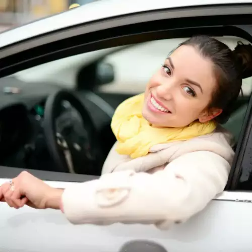 uśmiechnięta kobieta za kierownicą